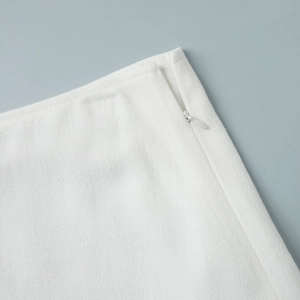 Detail of white textured fabric showing hidden side zipper on sleeveless dress set