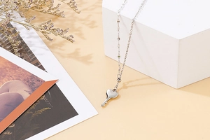 Macro detail of silver heart key pendant on a delicate bead chain necklace