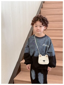 Detail of a cute beige bear-shaped crossbody bag with adjustable drawstring on a child