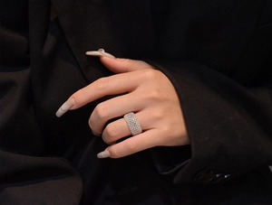 Close-up of a wide silver mesh ring with micro-pave cubic zirconia on a model hand