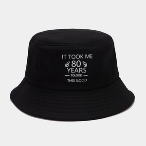 Detailed close-up of the black canvas bucket hat with white 80th birthday printed slogan