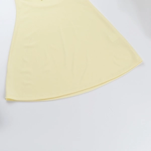 Dettaglio dell'orlo del vestito giallo chiaro con doppia cucitura ad ago e trama del tessuto