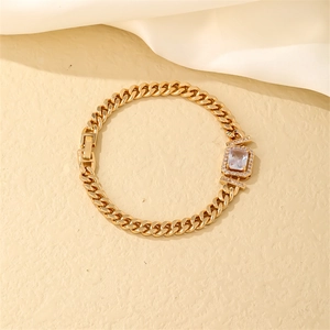 Detail of golden Cuban link bracelet with rectangle zircon inlay on silk background