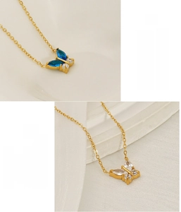 Detail of 18K gold-plated butterfly pendants with blue and white zircon on stainless steel