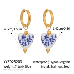 Detail view of gold heart earrings with blue enamel porcelain pattern and size metrics