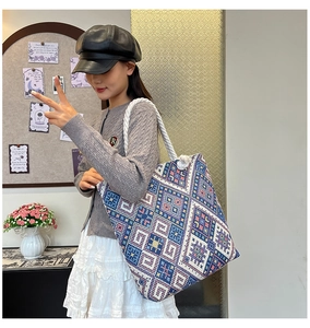 Detail of blue ethnic canvas tote bag with geometric embroidery and thick rope straps