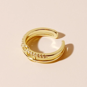 Close-up of golden double-layer crisscross ring with sparkling diamond inlay details