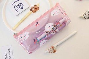 Macro detail of pink translucent pencil case with white cloud patterns and heart pendant