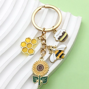 Golden honeycomb and bee charm keychain with sunflower and cupcake enamel pendants