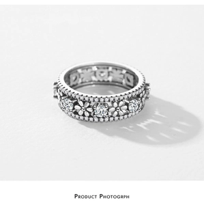 Macro detail of S925 sterling silver daisy ring with hollow pattern and micro-set cubic zirconia