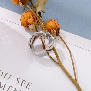 Detailed view of silver titanium steel X-ring with zircon inlay on an artistic background