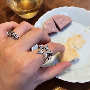 Primo piano dell'anello vintage con stella incisa e fascia multifilo su tavolo da tè