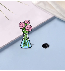 Close-up of enamel pin showing pink roses in a blue chemistry flask with rubber back