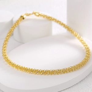 Detail shot of golden woven mesh chain necklace with lobster clasp on geometric stands