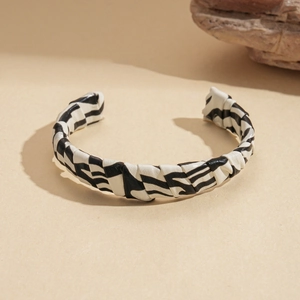 Detailed view of the black and white zebra print faux leather texture on the open bracelet