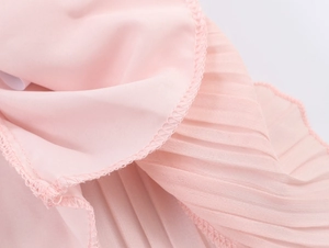 Detail of pink pleated chiffon fabric showing exquisite ruffle edge and soft texture