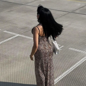 Detail of elegant leopard print camisole dress back view with a white handbag