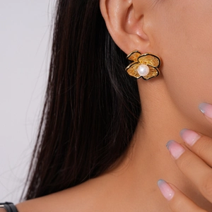 Detailed macro view of 18k gold plated hollow flower earring with a white pearl center