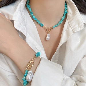 Detail of ethnic turquoise beaded necklace and bracelet set with baroque pearl and T-bar clasp