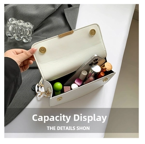 Internal view of a white pebble leather crossbody bag showing capacity for phone and makeup