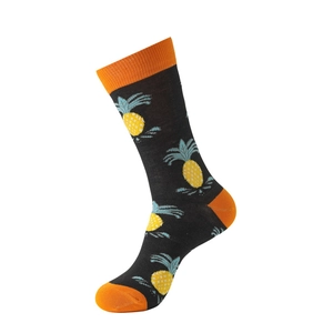 Detail of black cotton mid-calf sock with yellow pineapple pattern and orange toe accents