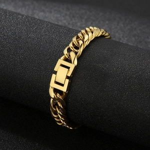 Polished gold double-link curb chain bracelet for men and women on a dark textured background