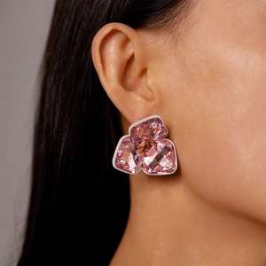 Close-up of pink crystal flower petal earring with silver twisted rope metal border