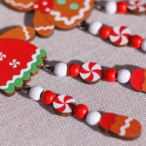 Handcrafted wooden gingerbread man Christmas tree ornament with festive beads and warm holiday colors