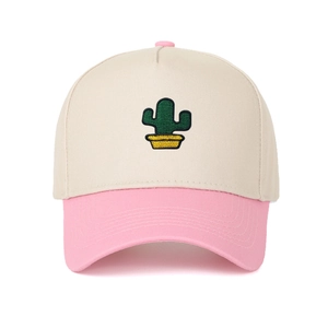 Détail de la broderie cactus sur une casquette trucker bicolore beige et rose pâle