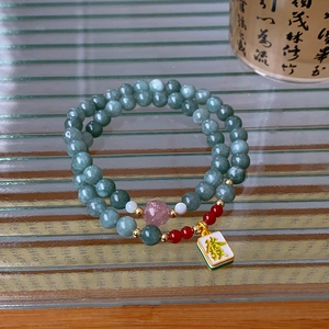 Detail of red agate and green jade double-layer bracelet with mahjong lucky charm