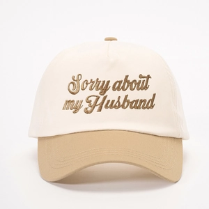 Gros plan de la broderie Sorry about my Husband sur une casquette de baseball bicolore
