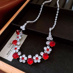 Macro detail of royal flower necklace featuring red gemstones and silver pavé crystals