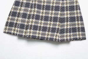 Gros plan détaillé du tissu en tweed à carreaux montrant le tissage noir et jaune de qualité