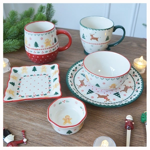 Detailed view of Christmas ceramic tableware set with Santa, elk and gingerbread patterns