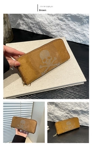 Detail of brown suede long wallet featuring silver rhinestone skull and zipper closure