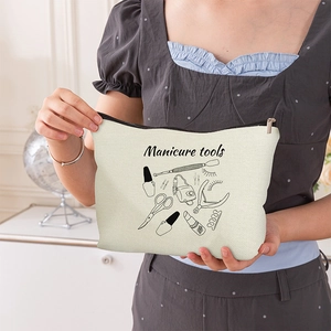 Portable beige canvas makeup bag with black manicure tools pattern and zipper closure