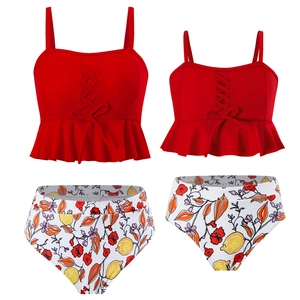 Détail d'un haut de tankini rouge avec nœud et bas de bikini floral à taille haute
