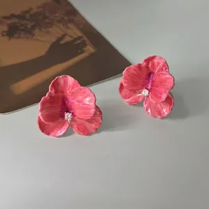 Elegant rose pink orchid petal stud earrings with crystal center on a minimalist grey surface
