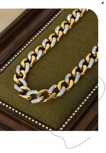Macro shot of gold-plated Cuban link necklace with sparkling pavé-set zircons on green