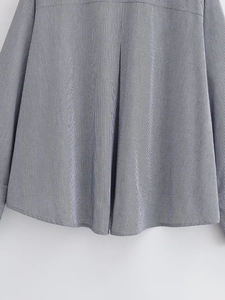 Close-up of black and white plaid shirt showing curved hemline and woven fabric texture