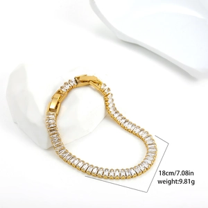 Detailed close-up of 18K gold tennis bracelet with zircon stones on decorative stone