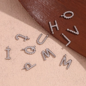 Minimalist silver stainless steel twist texture alphabet pendants on neutral background