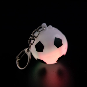 Glow-in-the-dark soccer ball keychain with red LED light and metallic carabiner clip