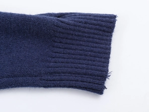 Close-up of dark blue knit POLO shirt showing ribbed cuffs and premium wool texture