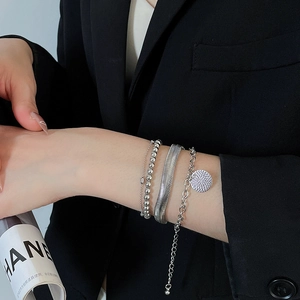 Dettaglio di un set di quattro bracciali argento con catena a serpente e ciondolo tondo