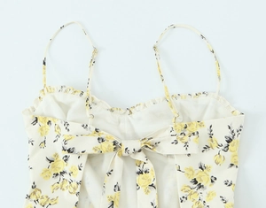 Detailed view of yellow floral midi dress featuring tie-back bow and delicate straps