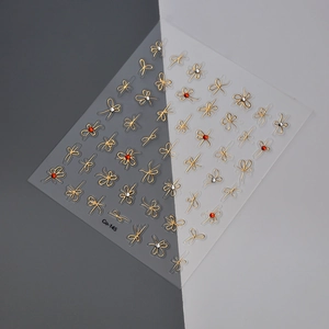 Detailed close-up of golden bow nail art stickers with small rhinestones, style Co-145