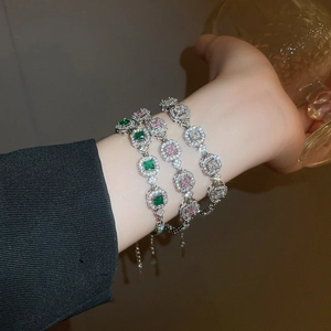 Close-up of geometric zircon bracelets in emerald green, pink, and clear crystal finishes