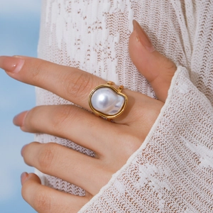 Elegant gold stainless steel ring with white baroque pearl on model's hand
