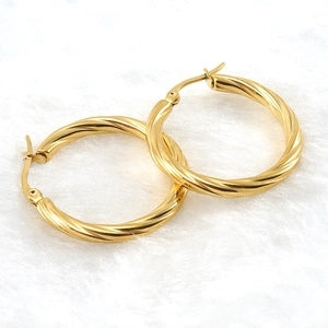 Classic 18K gold-plated stainless steel twisted hoop earrings on soft white fabric
